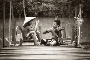 two kids setting on bridge, feeling simple with country life